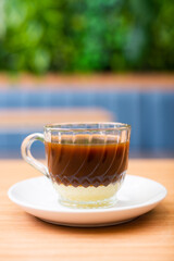 A glass of coffee served with condensed milk