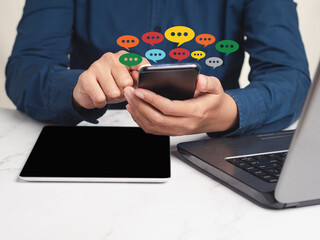 Close-up of hands using mobile phone with colorful chat icons on application communication digital