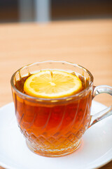 A Glass of hot lemon tea, served with a slice of lemon