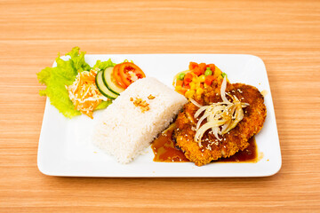 Chicken cutlet dish, served with rice and a side of salad topped with teriyaki sauce