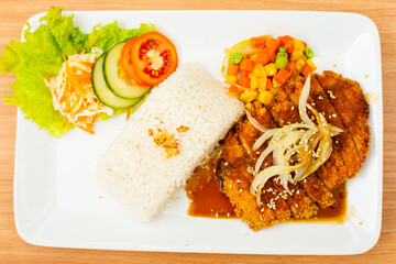 Chicken cutlet dish, served with rice and a side of salad topped with teriyaki sauce
