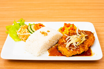 Chicken cutlet dish, served with rice and a side of salad topped with teriyaki sauce