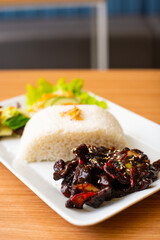 A Chicken Dish served with rice and a side of salad