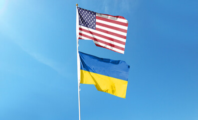 American flag and Ukrainian flag on cloudy sky. waving in the sky