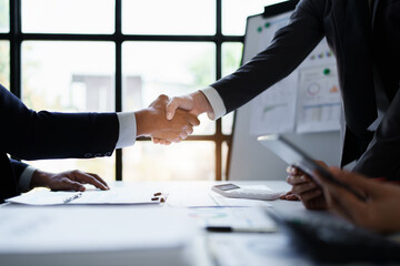 Asian entrepreneurs handshakes to congratulate the agreement between the two companies to enhance investment and financial strength. deal concept