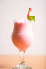 Strawberry milkshake served with a wafer straw