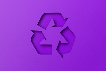 Purple paper punched cut into recycled shapes isolated on violet paper background.