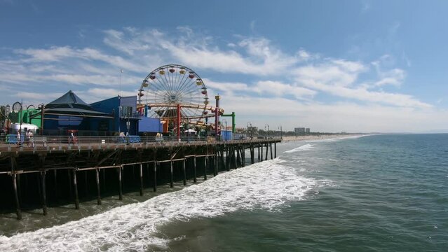 Famous Santa Monica ferris wheel amusement park with the Californian beach in the background on a how summer day