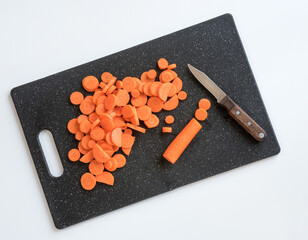  	Black Cutting Board with Sliced Carrots and Paring Knife