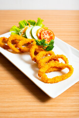Deep fried onion rings served with tartar sauce and chili sauce