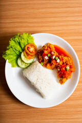 A Plate of spicy chicken deep fried chicken served with a plate of rice