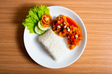 A Plate of spicy chicken deep fried chicken served with a plate of rice