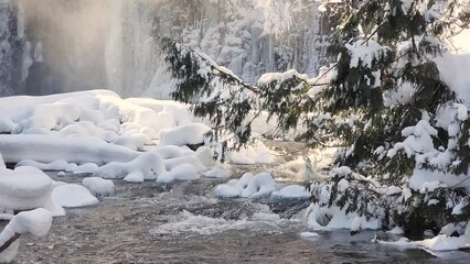 Dreamy wintery fast-flowing creek that runs through the frozen landscape in the forests of canada - Powered by Adobe