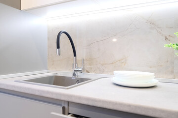 Modern flexible kitchen faucet. Modern classic kitchen interior with furniture