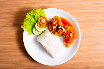 A Plate of spicy chicken deep fried chicken served with a plate of rice