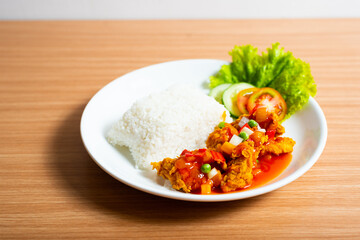 A Plate of spicy chicken deep fried chicken served with a plate of rice
