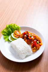 A Plate of spicy chicken deep fried chicken served with a plate of rice