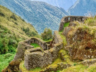 On the Inca Trail in Peru, old ruins of an Inkan stone building, shaped to blend with the natural surroundings in the Andes mountains.