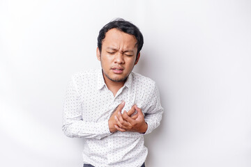Fototapeta premium Tired upset young man wears white shirt suffering from pain, muscle spasm at workplace. Fatigue, deadline, pain and incorrect posture