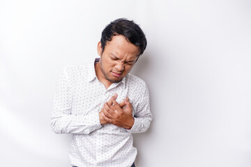 Tired upset young man wears white shirt suffering from pain, muscle spasm at workplace. Fatigue,...