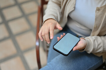 Top view of an Asian woman using her smartphone while relaxing outdoor.