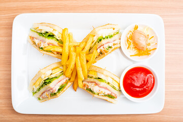 A Serving of club sandwich served with side of fries