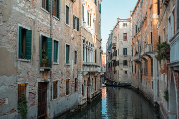Fototapeta na wymiar Venice Canal is lined on either side by Romanesque, Gothic, and Renaissance buildings in Venice, Italy.