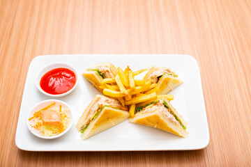 A Serving of club sandwich served with side of fries