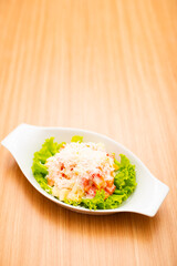 A Serving of healthy salad topped with mayonaise