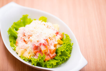 A Serving of healthy salad topped with mayonaise