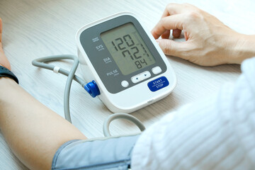 Man checks blood pressure monitor and heart rate monitor with digital pressure gauge. Health care...