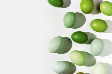 Easter eggs green gradient color, easter minimal trend frame, shadow at sunlight, light backdrop. Chicken eggs color eggshells, holiday food Easter background, top view, aesthetic flat lay, copyspace