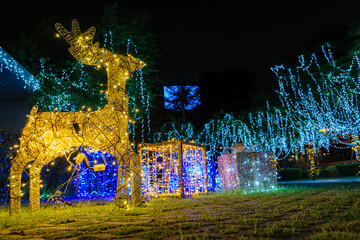 Sparkling figurine of Christmas Deer. Gold Christmas garland. Illumination at night. Winter...