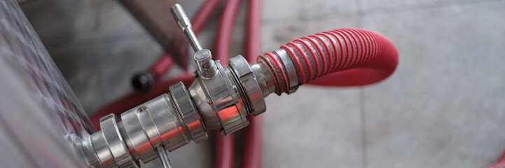 Industrial stainless steel pipe equipment with faucet and hose in wine production or chemical...