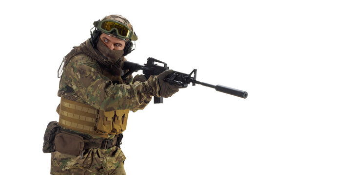Mercenary soldier with an automatic rifle in his hand looking by side.