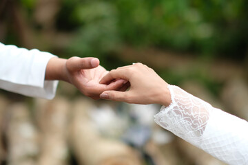 close up of bride and groom holding hands. a very romantic form of love language