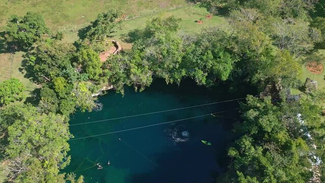 Tourist jumps from a rope in Dudu lagoon water, Cabrera in Dominican Republic. Aerial top-down view