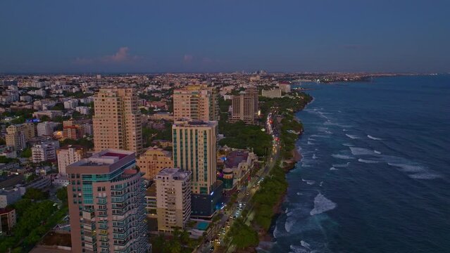 Modern buildings along Malecon at sunset. Aerial backward and sky for copy space 