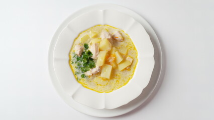 Creamy soup with chicken and vegetables close up in a plate on the table