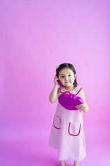 Pretty little girl playing with pretend plastic phone. 