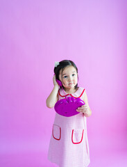Pretty little girl playing with pretend plastic phone. 