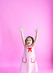 Pretty little girl stretching high above her head and reaching for the stars.