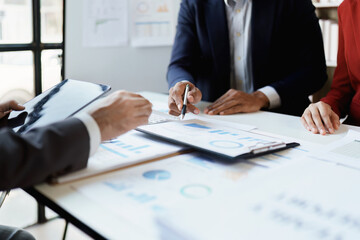 Team business adviser meeting to analyze and discuss the situation on the financial report n the meeting room with using calculator, documents, computer laptop in work.