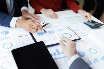 Team business adviser meeting to analyze and discuss the situation on the financial report n the meeting room with using calculator, documents, computer laptop in work.