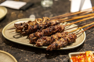 Authentic Uyghur Lamb Skewers with Fresh Ingredients, Served in a Traditional Restaurant, selective focus