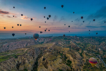 Amazing sunrise view of Cappadocia landscape in Turkey with lots of balloons flying