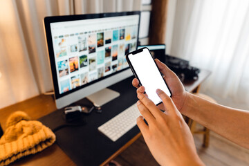 hand holding smartphone with blank screen in home desk