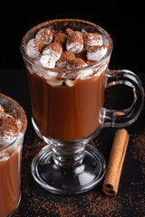 Two cups of hot chocolate, cocoa or warm drink with marshmallows on dark background
