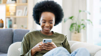 Young woman smiling and laughing while texting on a phone at home. Cheerful female chatting to her friends with apps, scrolling social media and watching funny internet memes while relaxing on a sofa - obrazy, fototapety, plakaty