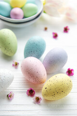  Easter eggs painted pastel colors on a white wooden background.